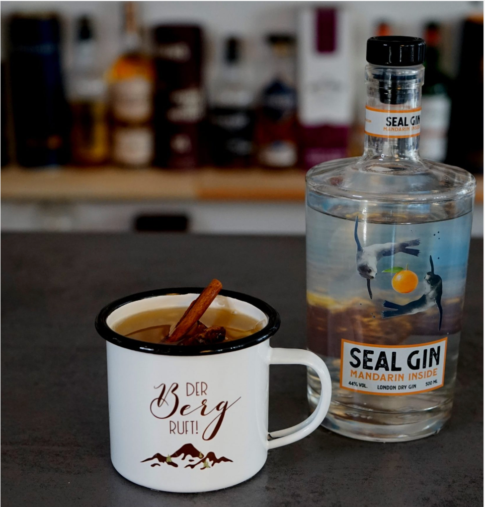 MANDARIN GLÜHGIN – heißer Cocktail in Glasbecher mit Zimtstangen, Apfelsaft und SEAL GIN Mandarin Inside, dekoriert mit Sternanis und Kardamom